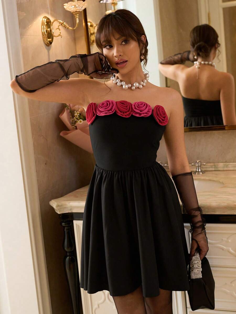 Full view of black backless strapless A-line mini dress with floral appliqué neckline
