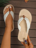 Overhead beige and white textured flip-flops shown worn and held outdoors