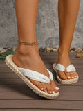 Low front view of subtle white textured thong sandals with beige soles