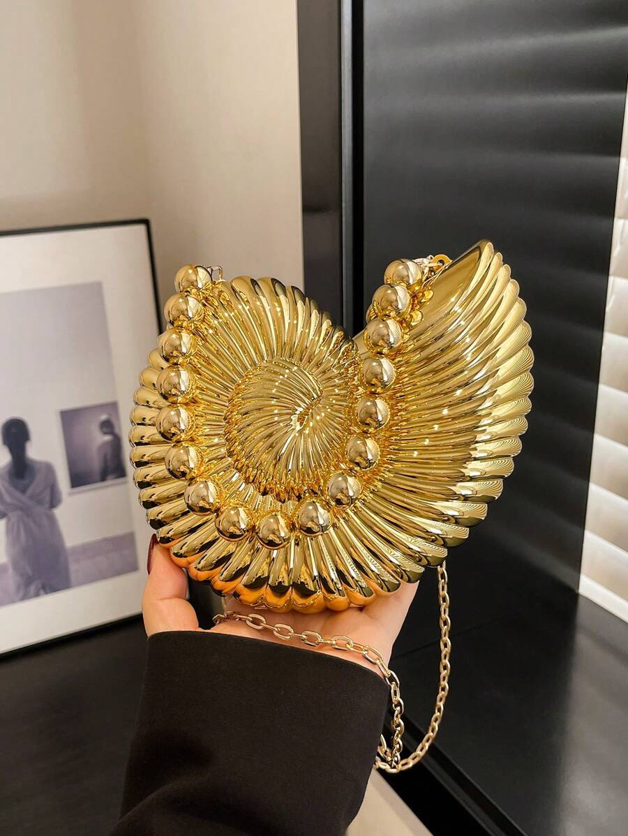 Add a splash of seaside charm to your evening look with this elegant golden conch-shaped shoulder bag. Its shimmering finish and unique shell design make it a standout accessory, while the detachable strap lets you switch from shoulder to clutch in a snap. Perfect for turning heads and carrying your essentials with a playful twist on sophistication.