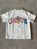 Front view of white women’s Jesus graphic T-shirt with multicolor religious lettering