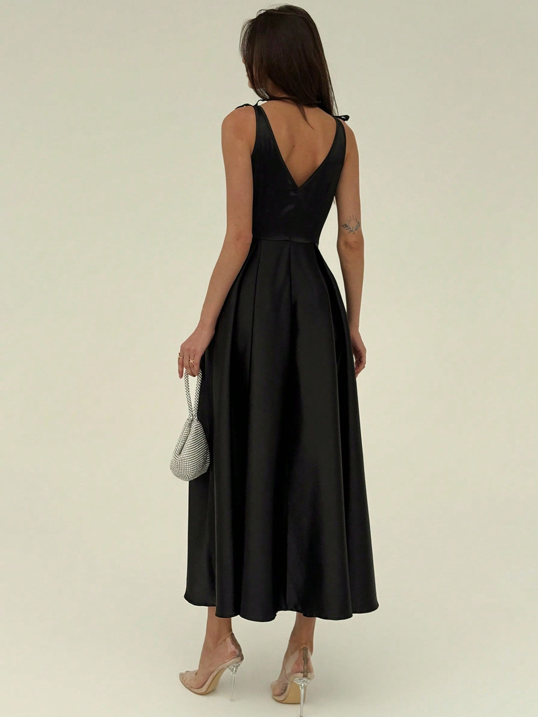 This sleek black satin dress pairs minimalist charm with a flirty bow detail, making it ideal for modern parties. Its smooth fabric catches the light, while the subtle design keeps you effortlessly chic. Slip into this dress to turn heads and keep the vibe fun and fresh all night long.