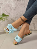 Close-up of mint blue bow sandal with flat black outsole
