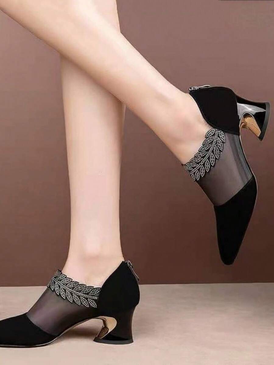 Angled pair view of black mesh patchwork pumps with glossy sculpted heel