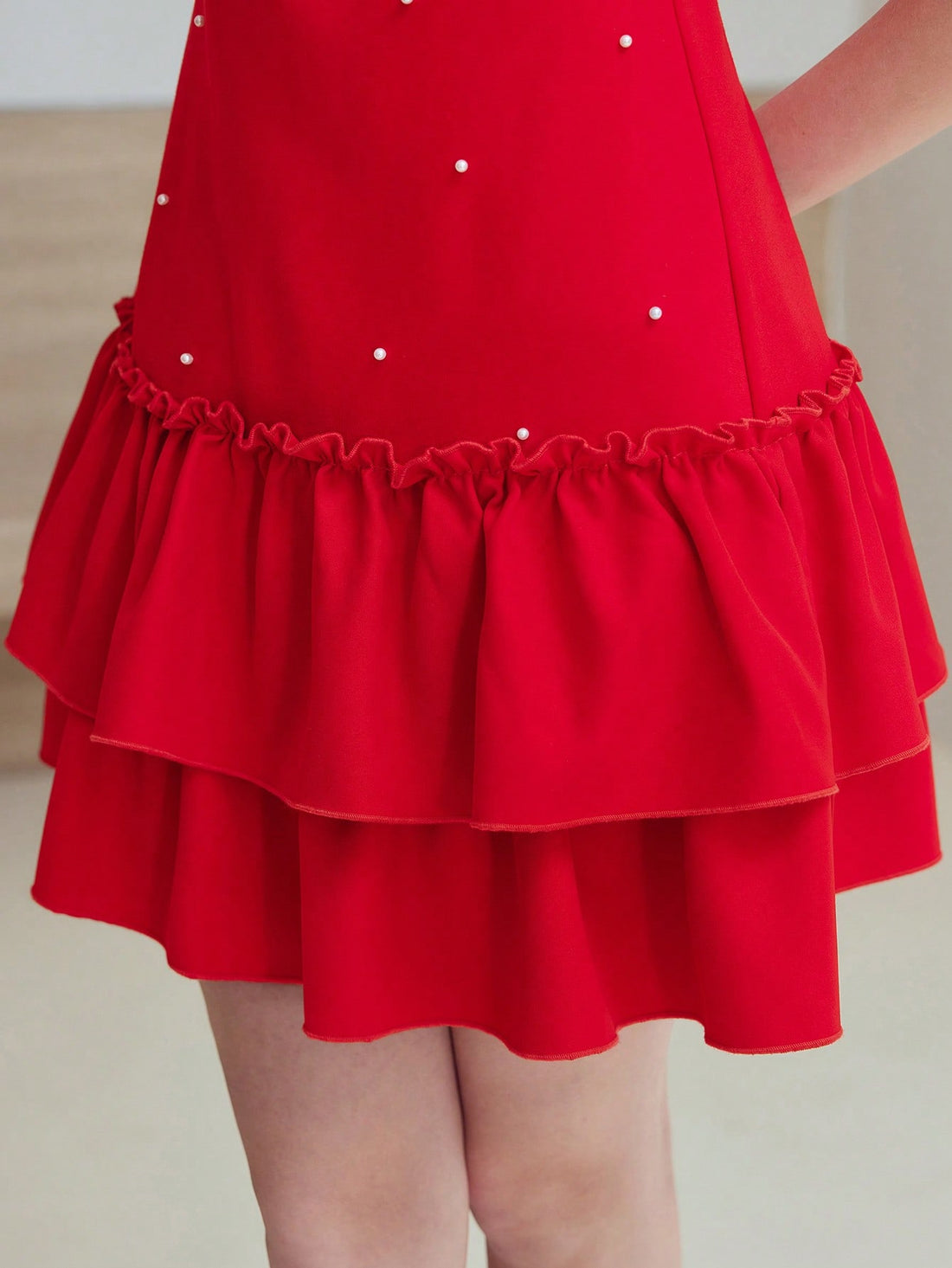 Step out in style with the Faux Pearl Ruffle Hem Dress, where elegance meets a playful twist. Delicate faux pearls add a touch of charm, while the flirty ruffle hem brings movement and fun to every step. Perfect for any occasion, this dress effortlessly blends chic sophistication with a lively spirit.