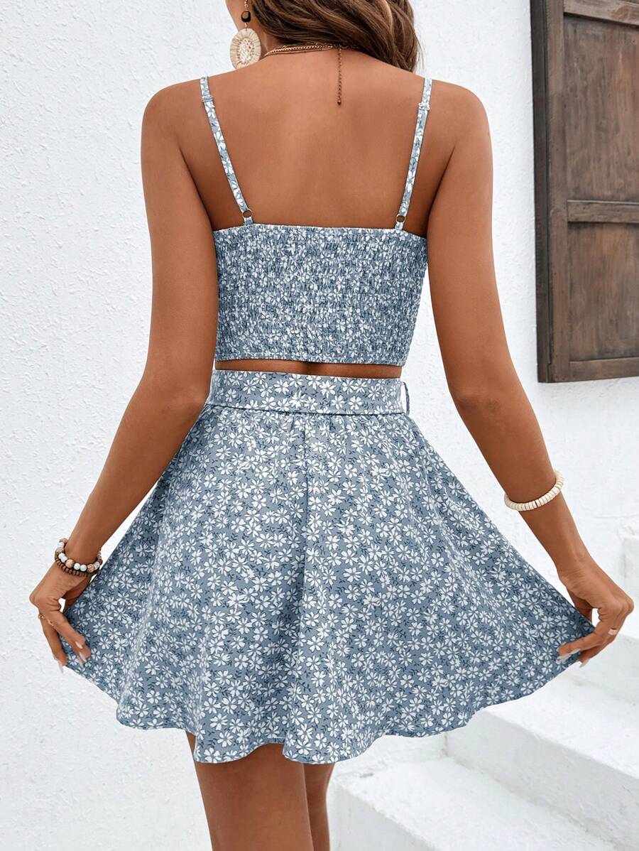 Elevate your warm-weather wardrobe with this charming floral set featuring a cropped camisole and coordinating mini skirt. The ditsy floral print in soft blue brings effortless boho style, while thoughtful details like shirring at the bust, ruching, and a belted waist create flattering definition. Spaghetti straps and a regular fit offer comfortable everyday wear, perfect for beach days, festivals, or vacation getaways. Crafted from a durable polyester-elastane blend, this set pairs beautifully with sandals