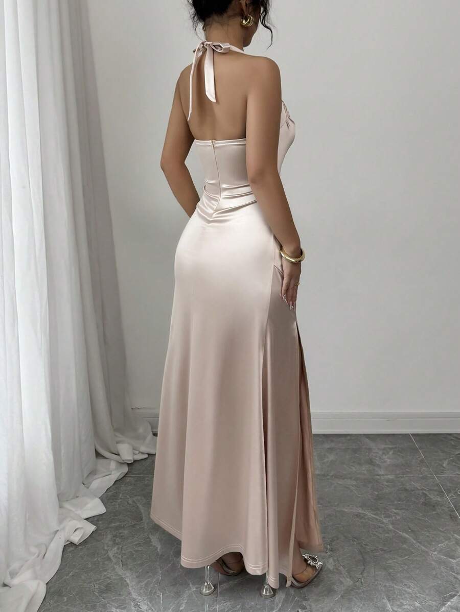 View 1 of champagne satin halter slit maxi dress with open back, ruched waist, neck tie straps, and high slit