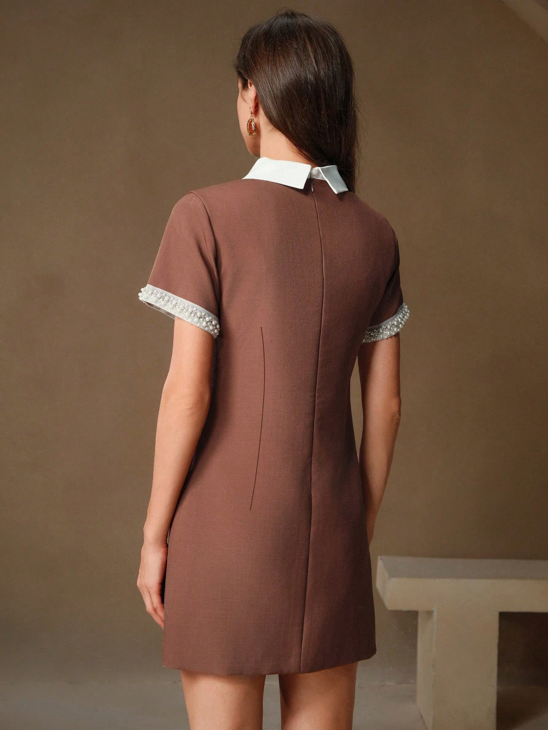 This dress will make you the talk of the town with its chic design. The rhinestone and pearl embellished lapel adds a touch of elegance to the Maillard colored fabric. Stand out in style and turn heads with this unique dress. Look effortlessly fashionable in this one-of-a-kind design.