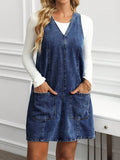 Full front view of deep blue washed denim pinafore mini dress with relaxed A-line silhouette