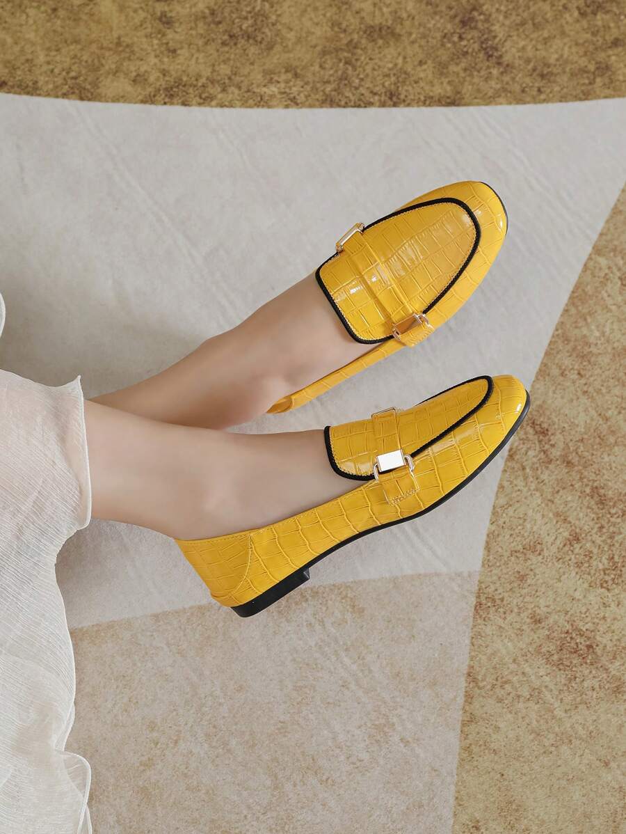 Close-up of yellow PU leather loafer showing glossy texture and low sole