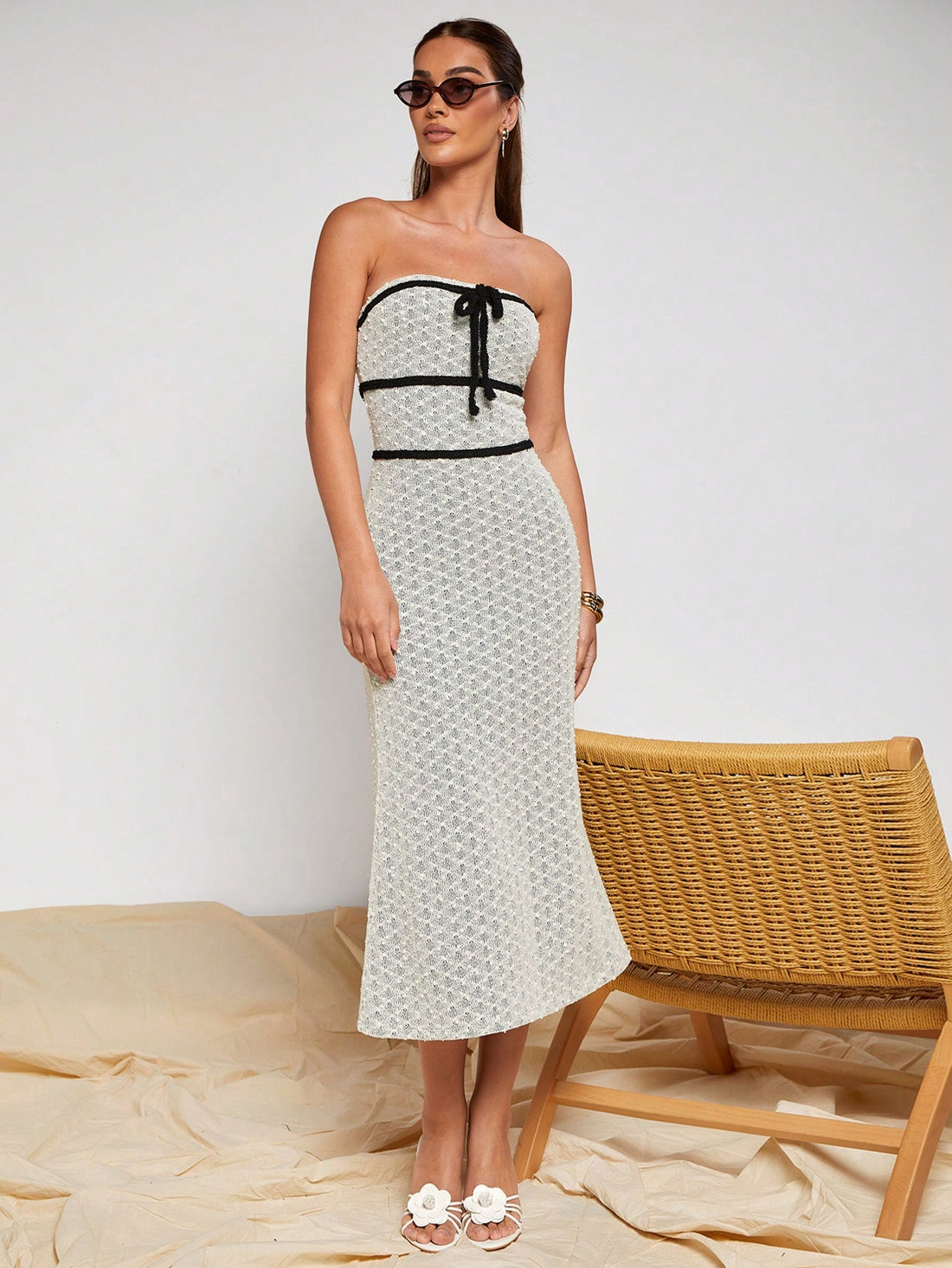 Slip into effortless sophistication with this stunning strapless midi dress that's equal parts chic and fun. Crafted from soft, breathable knitted fabric, it hugs your curves in all the right ways while the elegant black trim adds a touch of drama. The charming tie-front detail lets you customize your look—cinch it tight for a defined silhouette or keep it loose and breezy. Perfect for date nights, garden parties, or whenever you want to feel absolutely fabulous without trying too hard.