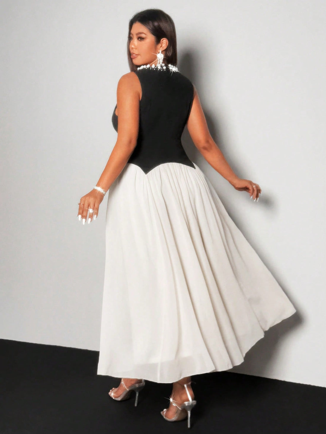 Step into effortless elegance with this chic plus size chiffon dress featuring a striking pearl and black color block design. Its flowing fabric moves gracefully, making every moment feel special. Perfect for turning heads with a playful touch of sophistication.