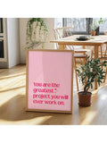 Framed pink quote poster styled beside a sofa in a bright room
