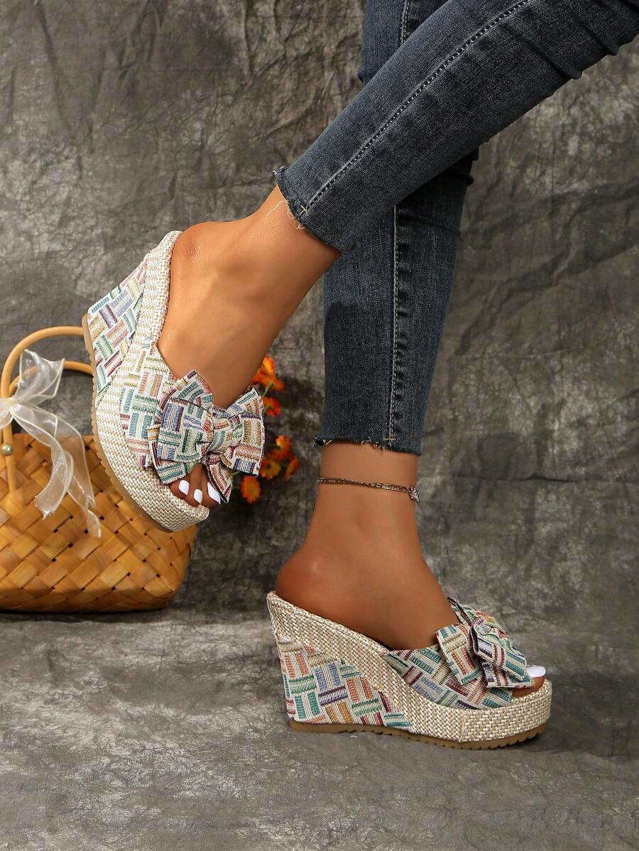 Multicolor bowknot wedge slide sandals with raffia-like platform and open toe.