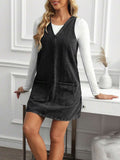 Front three-quarter view of washed black A-line denim mini dress layered for casual styling