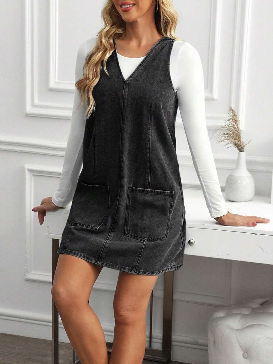 Front three-quarter view of washed black A-line denim mini dress layered for casual styling