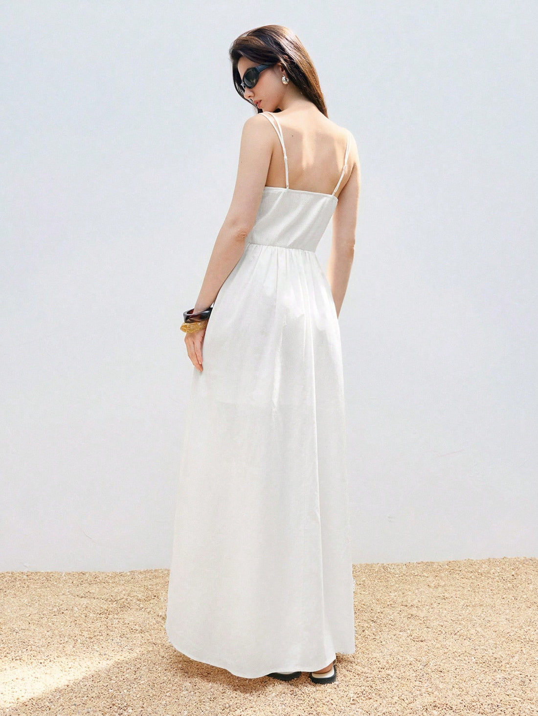 Step into summer with this playful white suspender dress featuring delicate pleated fabric and a breezy high slit. Its bohemian charm and casual chic style make it perfect for sunny days and spontaneous adventures. Light, elegant, and effortlessly stylish, this dress adds a fun twist to your warm-weather wardrobe.