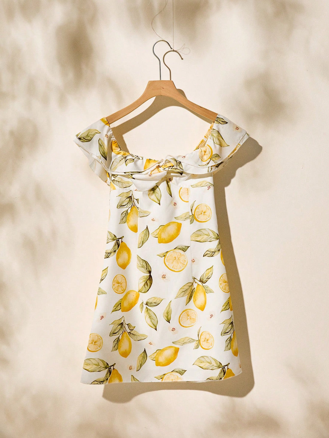 Embrace sunny days in this playful butter yellow off-shoulder dress, adorned with a charming vintage fruit pattern. Perfect for vacation vibes, its breezy design keeps you cool while adding a touch of boho chic to your summer wardrobe. Whether strolling the beach or sipping cocktails, this dress brings effortless style and cheerful energy to every moment.