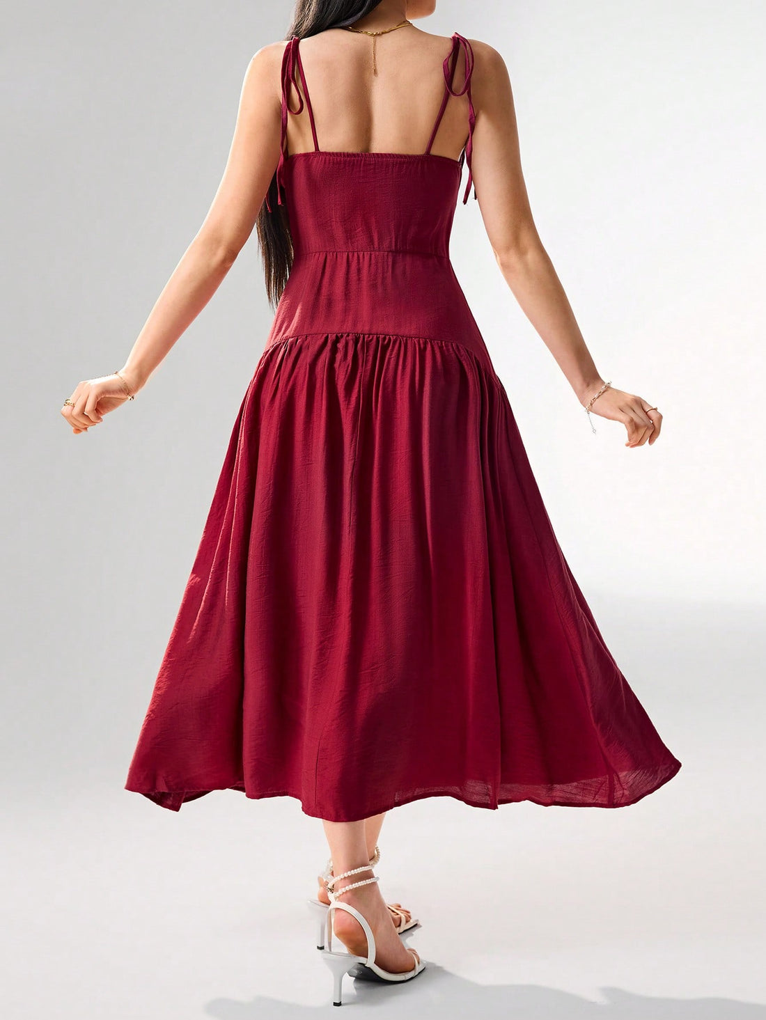 Get ready to turn heads with this elegant and playful camisole dress! The ruffle shoulders add a touch of fun while the knot detail cinches the waist for a flattering silhouette. Perfect for any occasion, this dress comes in a variety of solid colors that are sure to make a statement.