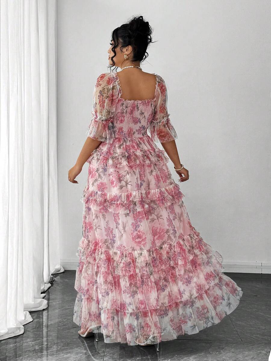 Front three-quarter view of pink floral plus size tiered maxi dress for summer weddings