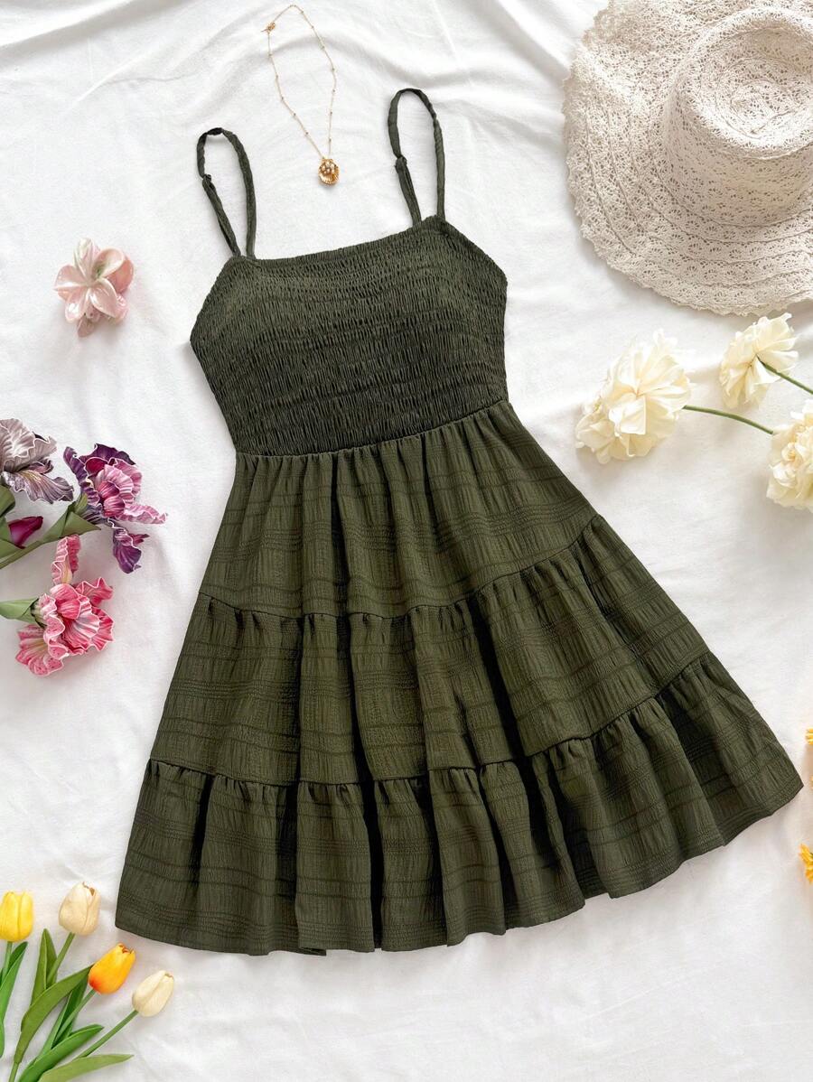 Olive smocked cami mini dress flat lay with tiered ruffle skirt hat flowers and necklace