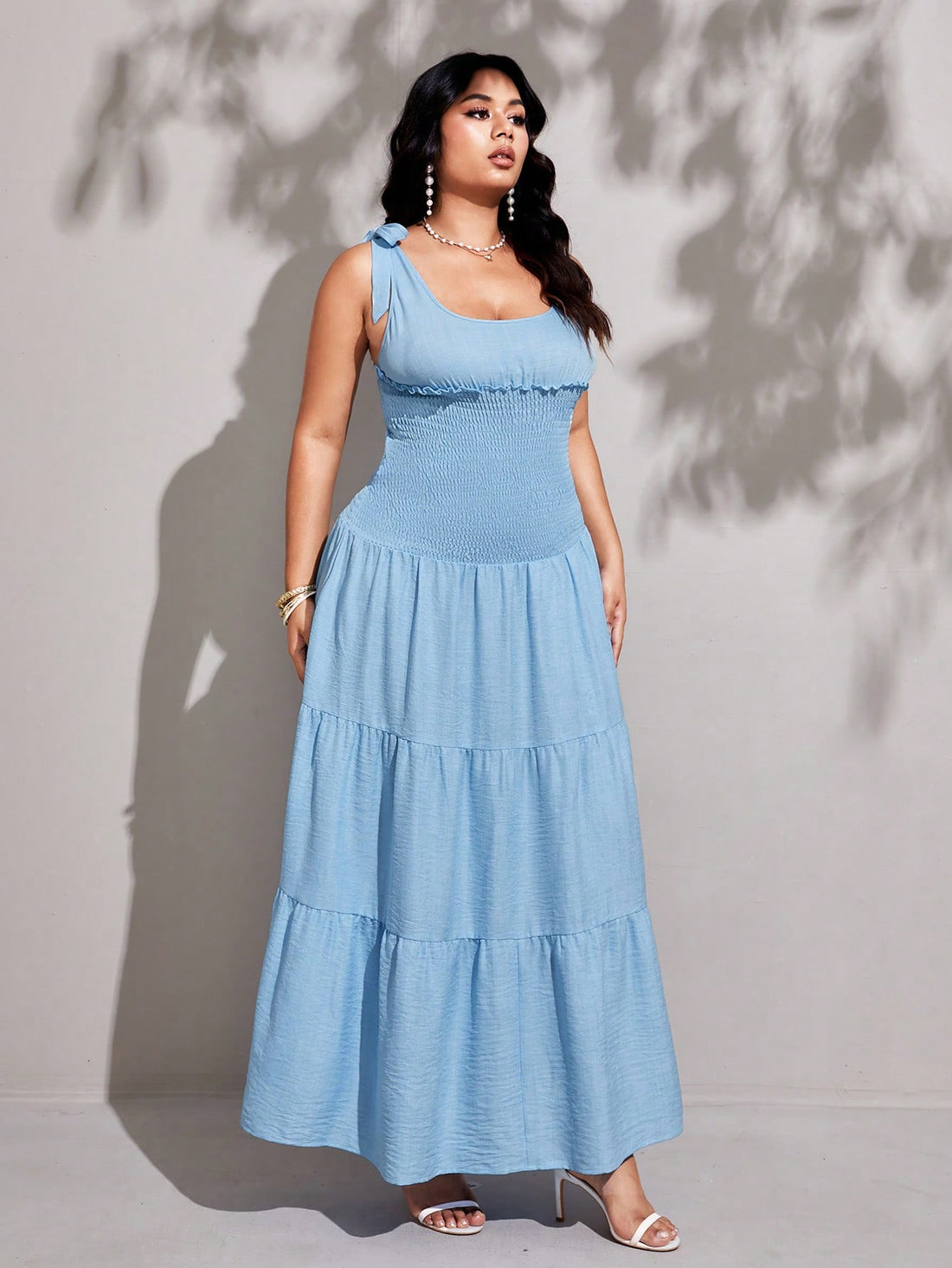 Step out in style with this Elegant Plus Size Women's Solid Smocked Ruffle Hem Sleeveless Dress. The smocked bodice offers a comfy, flattering fit, while the playful ruffle hem adds a flirty touch. Perfect for sunny days or casual outings, this dress combines comfort and charm effortlessly. Embrace your curves and let your confidence shine!