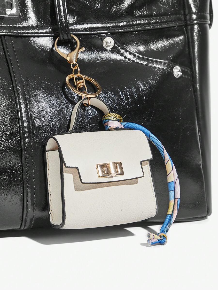 Close-up view of mini key ring holder keychain coin purse earphone pouch bag charm with chain strap, coin purse format, key ring detail for small-item storage