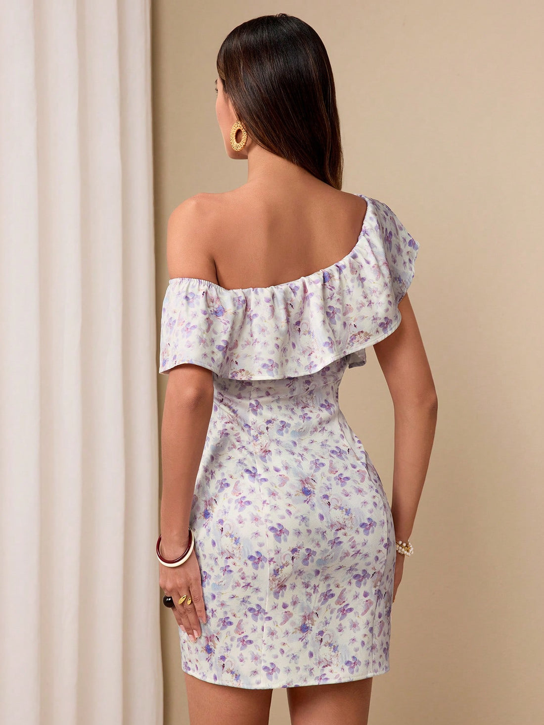 Channel your inner floral goddess with this sophisticated mini dress. With a ruffled asymmetrical neck and a funky floral print, you'll be turning heads wherever you go. Feel empowered and effortlessly stylish in this playful and flirty dress.