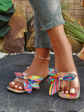 Side view of colorful flat sandal with oversized bow upper