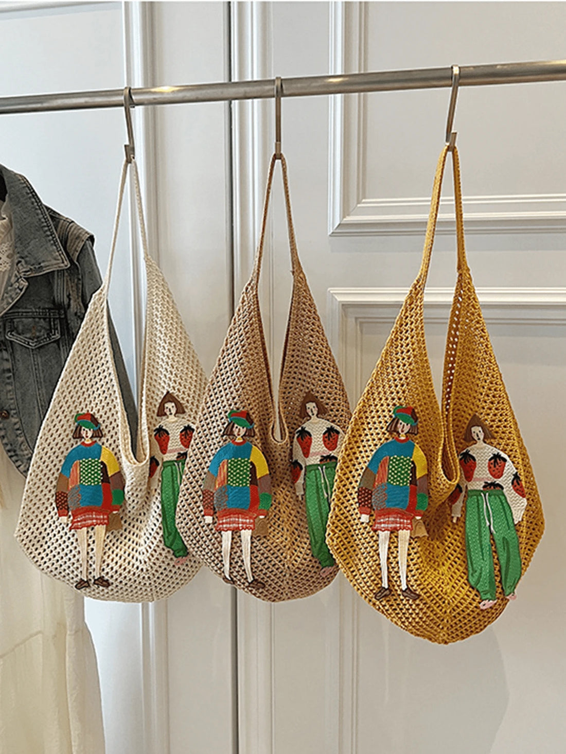 Cream tan and mustard crochet mesh shoulder bags hanging with colorful figure appliques