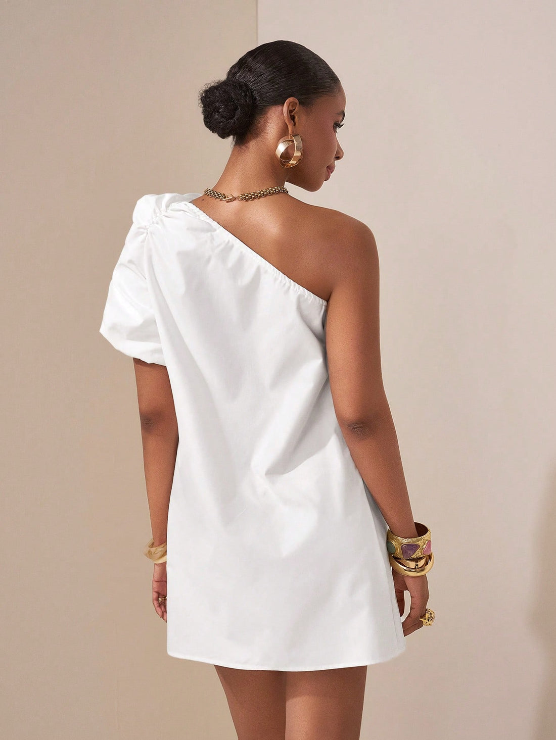 Step into the spotlight with this playful white mini dress featuring charming puff sleeves and a trendy asymmetric hem. Its breezy design makes it your go-to for spring festivals or sunny beach getaways, combining comfort with a flirty, fresh vibe. Embrace effortless style and let your fun side shine!