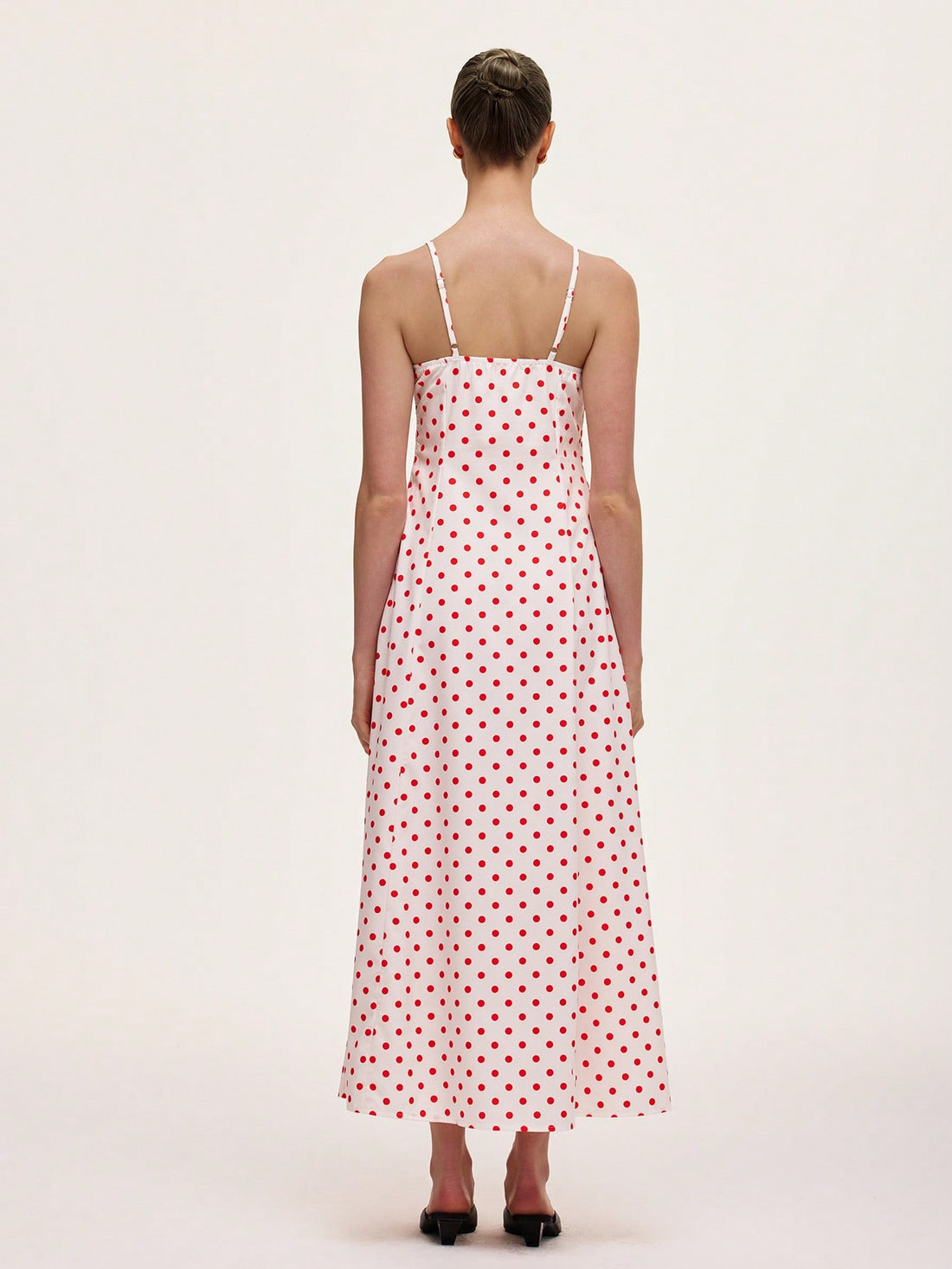 This playful polka dot cami midi dress is designed to flatter your figure with a waist-cinching silhouette that adds a touch of charm to your look. Its breezy midi length and delicate straps make it perfect for effortless style, whether you're out for brunch or dancing the night away. Embrace fun and feminine vibes with this chic wardrobe staple.