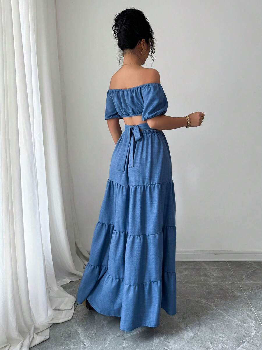 Turn heads this summer in a dress that's equal parts daring and effortless. This off-shoulder, backless stunner features a chic denim effect that brings casual cool to any vacation getaway. The flowing long silhouette keeps things breezy and comfortable while the bold cutouts make a statement that says you're ready for adventure. Perfect for beach days, sunset dinners, or anywhere your summer takes you—this dress is your new travel essential.