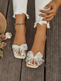 Side view of cream bow slide sandal with square open toe