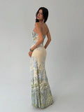 Back side view of cream blue green floral maxi dress with low square back and thin straps
