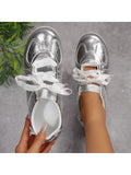 Top-down view of metallic silver low-top sneakers showing padded white collars