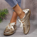 Rear side view of metallic gold fashion sneakers with gum soles and instep straps