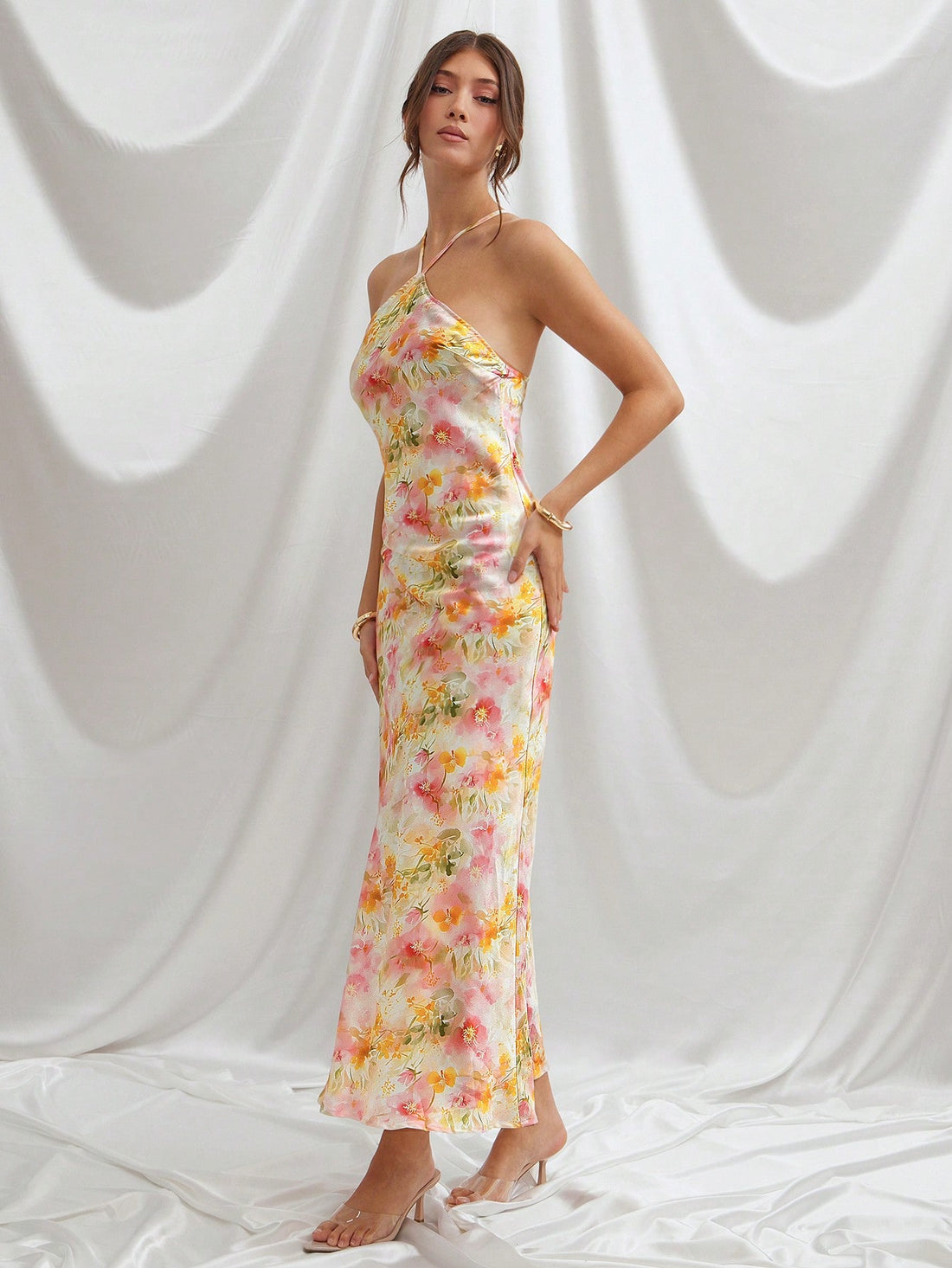 Step into the spotlight with this Elegant Floral Multicolor Satin Halter Neck Maxi Dress. Its silky satin fabric flows effortlessly, while the vibrant floral print brings a burst of summer joy. The halter neck design adds a flirty touch, making it a charming choice for weddings or any formal event where you want to shine. Feel confident, fun, and ready to dance the night away in this dazzling maxi dress!