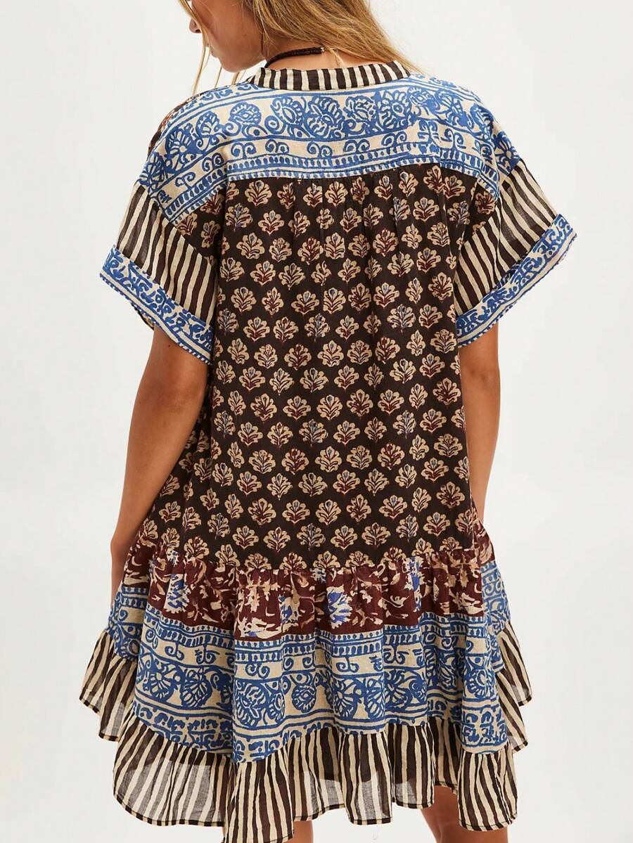 Front three-quarter view of brown mixed-print deep-V mini dress with striped ruffle hem