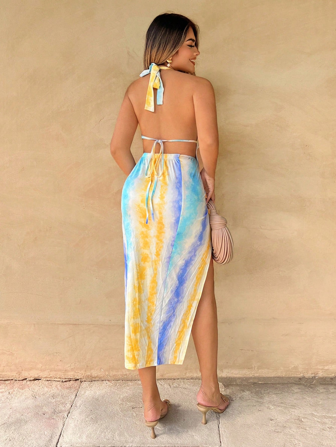 Escape the ordinary in this vibrant tie-dye vacation dress that's equal parts fun and fabulous. The adjustable tie neck lets you customize your look, while the flowy silhouette keeps you cool and comfortable through sun-soaked days. A cheeky split hem adds movement and personality to every step. Perfect for beach strolls, poolside hangs, or spontaneous adventures—this dress transforms any getaway into a style moment. Pack it, wear it, love it.