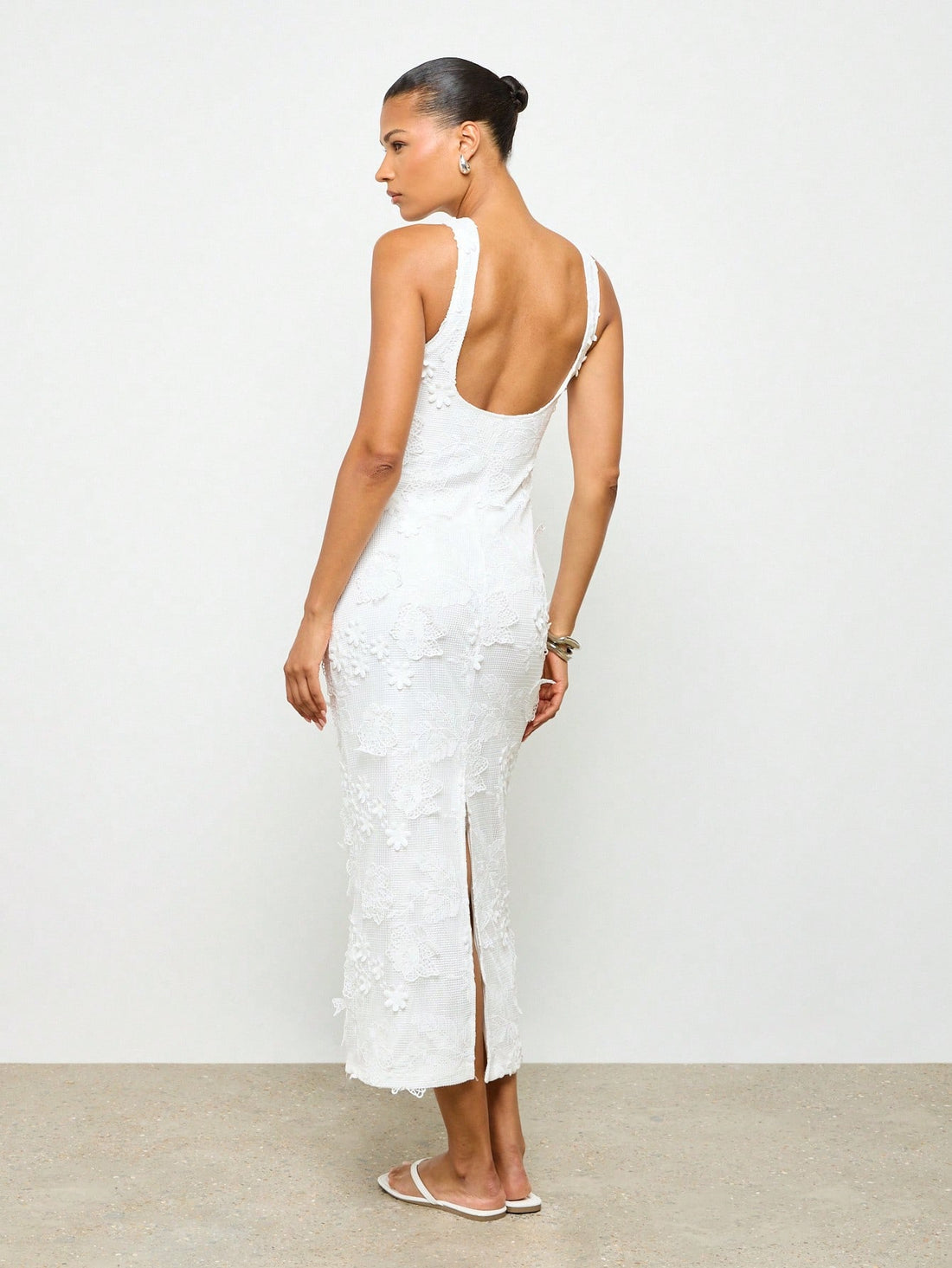 Step into the spotlight with this elegant floor-length white lace bridal dress, designed to make every moment magical. The delicate applique adds a touch of whimsy, while the sleeveless cut and daring side slit keep things light and breezy for summer soirées. Perfect for weddings or garden parties, this gown lets you dance through the evening with effortless charm and flirtatious flair.