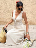 Seated three-quarter view of apricot V-neck vacation dress with front knot and flared skirt