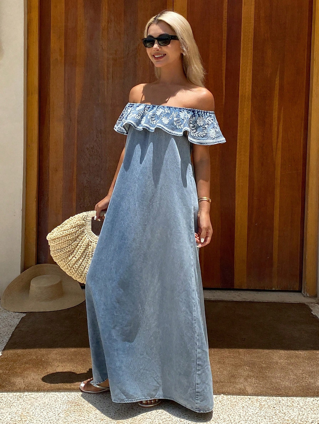 Elevate your vacation wardrobe with this sophisticated denim maxi dress, designed for effortless elegance. The off-shoulder neckline creates a flattering silhouette while delicate ruffles add movement and dimension throughout. Intricate embroidery detailing brings refined artistry to the classic denim fabric, transforming a timeless piece into something distinctly special. Perfect for warm-weather getaways, this dress transitions seamlessly from daytime exploration to evening occasions. The maxi length offe
