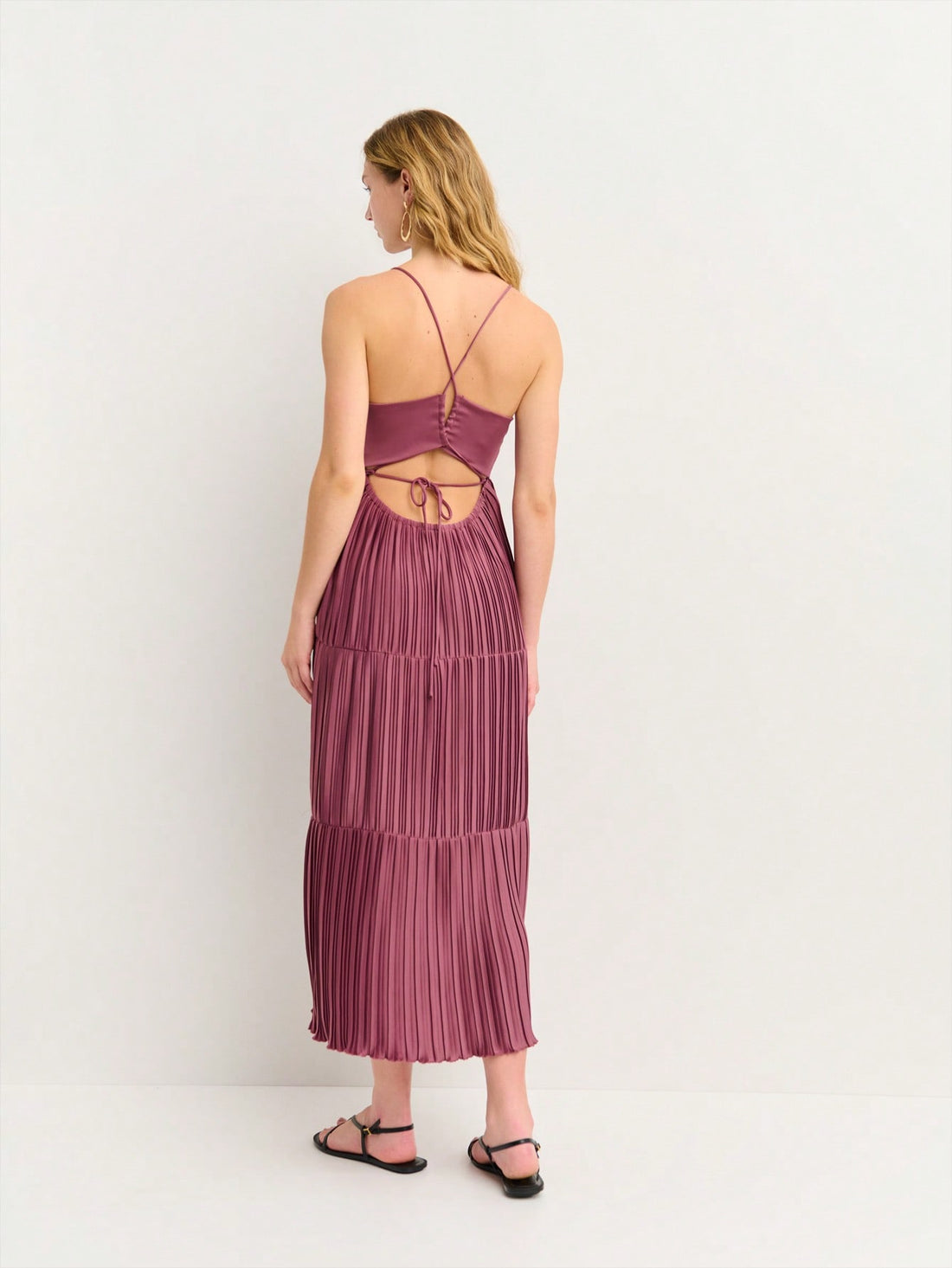 Turn heads at your next summer celebration in this effortlessly chic midi dress. The flattering V-neckline draws attention upward while the strappy back detail adds an unexpected twist of allure. Crafted from lightweight fabric, it's breathable enough for all-day wear at festivals and parties without sacrificing style. Whether you're dancing under the stars or sipping cocktails with friends, this versatile piece transitions seamlessly from day to night. The midi length offers just the right amount of covera