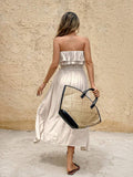 Rear resort view of cream strapless A-line dress with layered ruffle neckline and waist belt