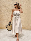 Full front resort view of cream strapless vacation dress with tied waist and flowing A-line hem