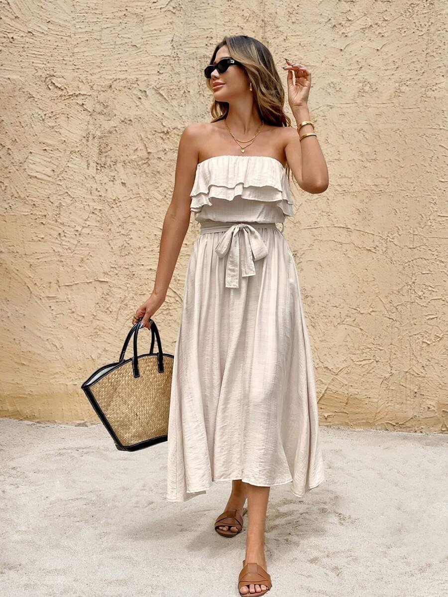 Full front resort view of cream strapless vacation dress with tied waist and flowing A-line hem