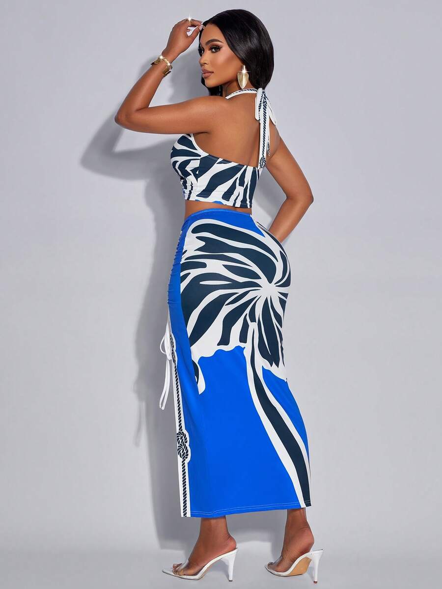 Make a statement with this stunning two-piece set featuring a sleeveless halter camisole and high-slit maxi skirt in a captivating tropical print. The backless camisole showcases a chic knot detail, while the skirt's metal ring buckle adds an edgy touch. Crafted from a comfortable polyester-elastane blend with slight stretch, this set delivers both style and comfort for night-out occasions. Machine wash for easy care. Perfect for creating an unforgettable look.