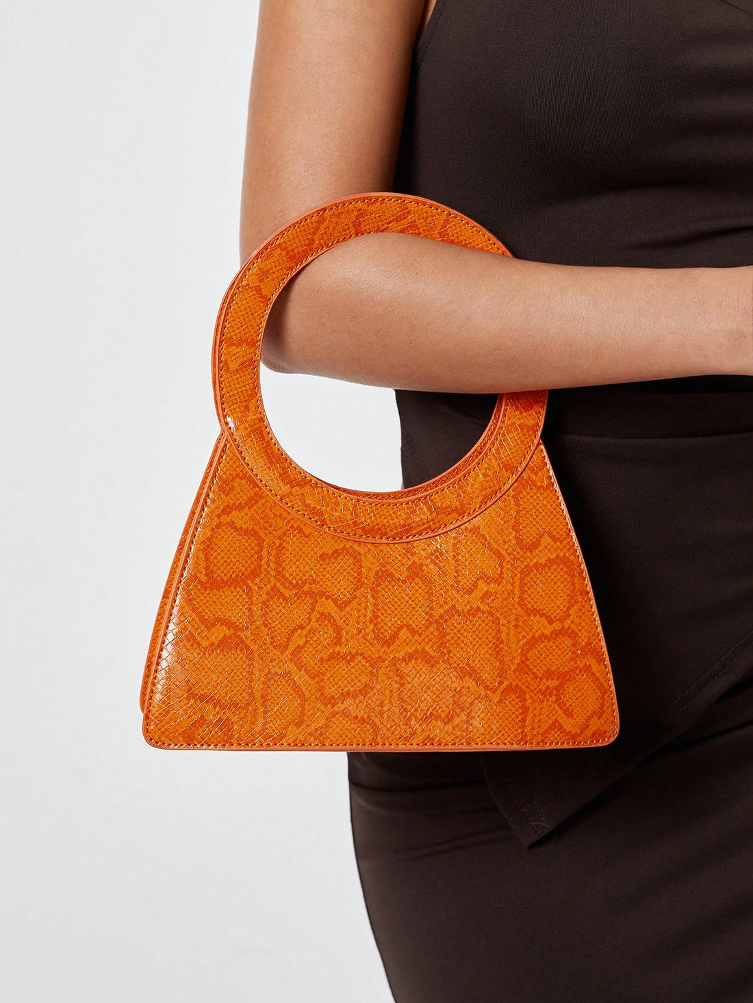 This sophisticated top handle bag combines striking orange snake print with timeless elegance, making it an essential accessory for the modern woman. The structured silhouette and premium craftsmanship ensure durability while the versatile design transitions seamlessly from office to evening events. The comfortable top handle provides practical carrying ease, while the bold print adds an instant fashion-forward edge to any outfit. Perfect for those who appreciate quality construction and distinctive style, 