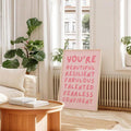 Close-up of coral motivational lettering on blush pink wall art